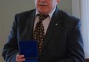 Z. Witkowski, Prezes Towarzystwa Miłośników Ziemi Kościańskiej prezentuje medal odlany z okazji 50-lecia powstania Towarzystwa
